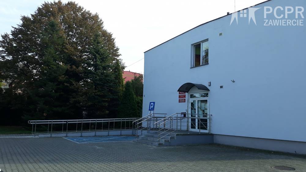 Zdjęcie: Front budynku Powiatowego Centrum Pomocy Rodzinie w Zawierciu wraz z miejscem parkingowym oraz podjazdem dla osób niepełnosprawnych